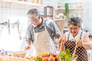 two seniors are cooking a nutritious meal together after learning healthy eating in their senior nutritional counseling
