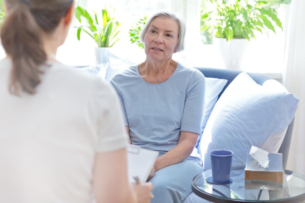 a senior woman sits and listens to her occupational therapist in her senior occupational therapy program