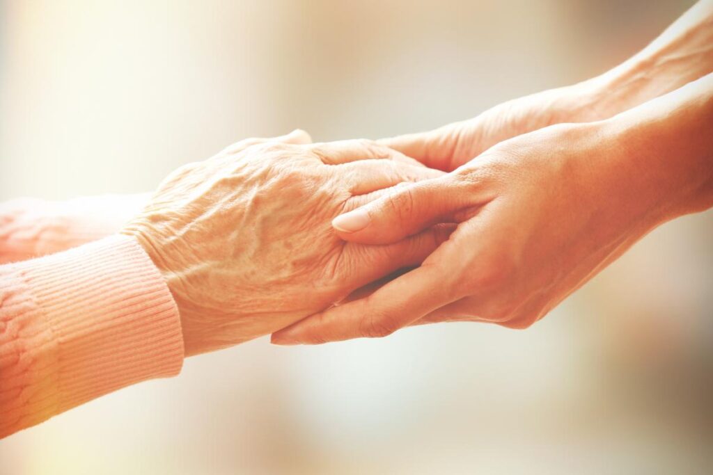 a photo of a young adult holding hands with senior adult after explaining what is senior respite care